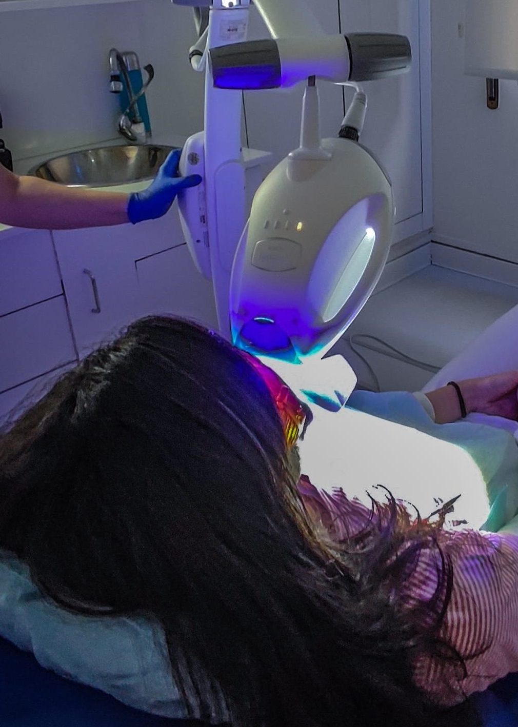 chica recibe tratamiento de blanqueamiento dental